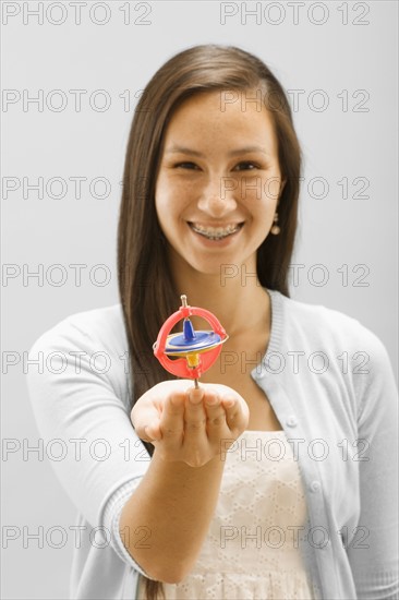 Studio portrait of young woman holding gyroscope. Photo : FBP