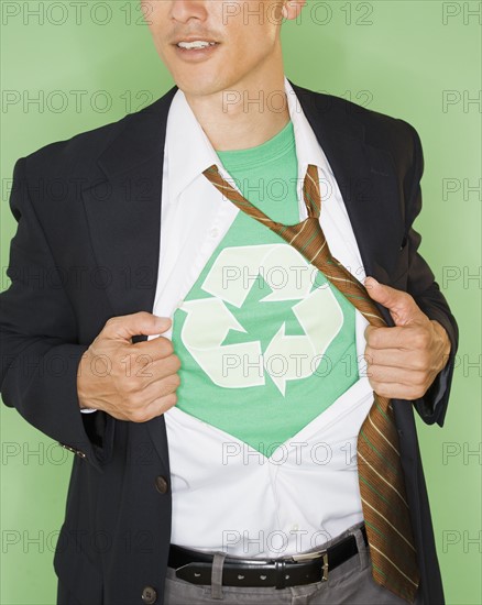 Businessman with wearing t-shirt with recycling symbol under suit, studio shot. Photo : Jamie Grill