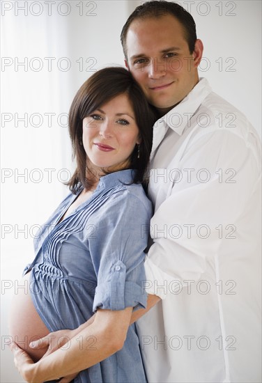 Young man hugging pregnant woman. Photo : Jamie Grill