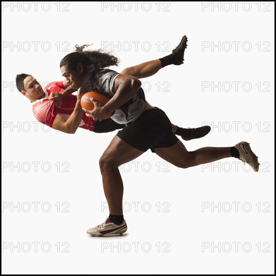 Rugby players tackling for ball. Photo : Mike Kemp