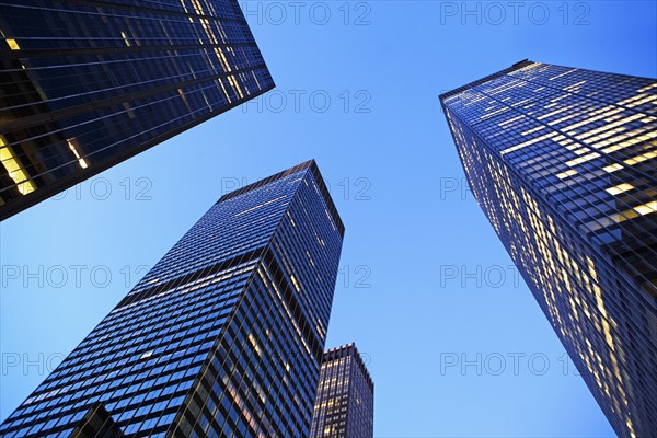 USA, New York State, New York City, Manhattan, low angle view of office buildings illuminated at dusk. Photo : fotog
