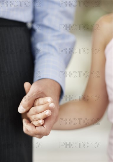 Granddaughter (10-11) and grandfather holding hands. Photo : Momentimages