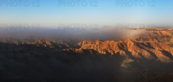 USA, South Dakota, Mountains in morning fog in Badlands National Park.