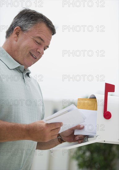 USA, New Jersey, Jersey City, Man checking mail in mailbox.