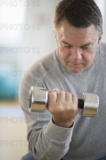 USA, New Jersey, Jersey City, Fitness instructor assisting man using hand weight in gym.