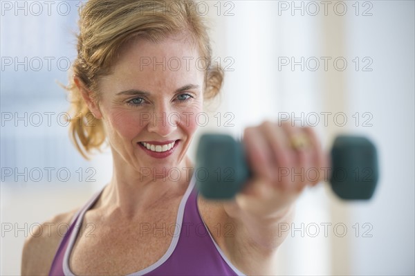 USA, New Jersey, Jersey City, Woman using hand weights at gym.