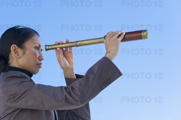 USA, New Jersey, Jersey City, Woman looking through telescope.