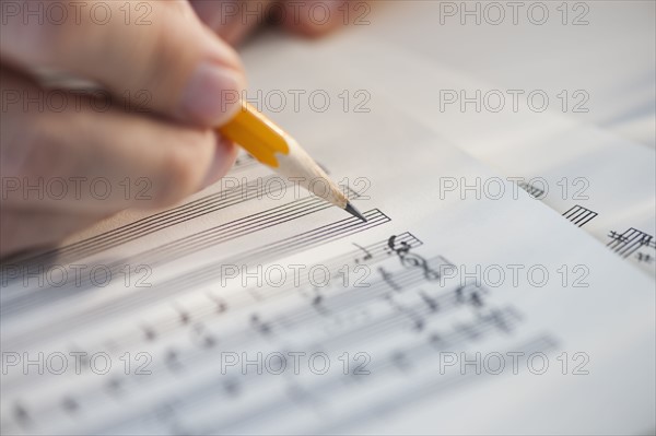 Man writing notes on sheet music.