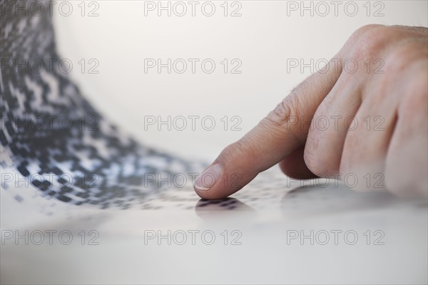 Human finger touching DNA chart.