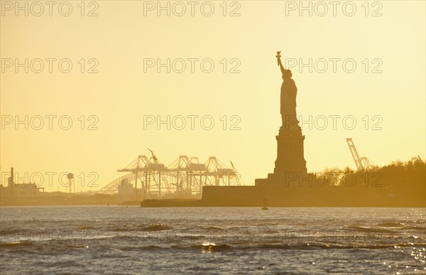 USA, New York City, Staten Island, Harbor and silhouette of Statue of Liberty in background.