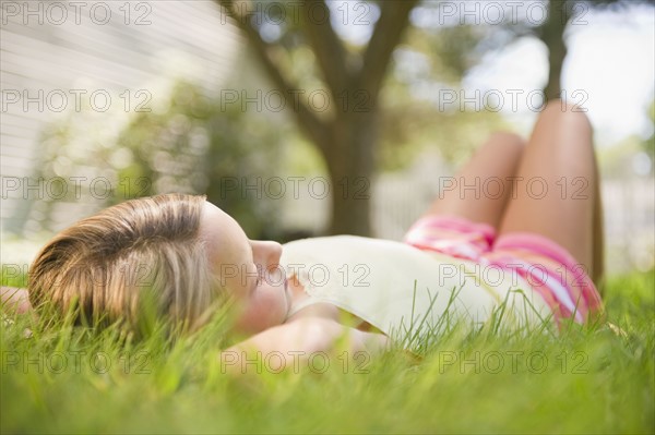 USA, New York, Girl (10-11) relaxing in park. Photo : Jamie Grill Photography