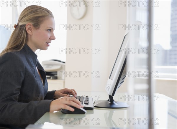 USA, New Jersey, Jersey City, Businesswoman working on computer. Photo : Jamie Grill Photography