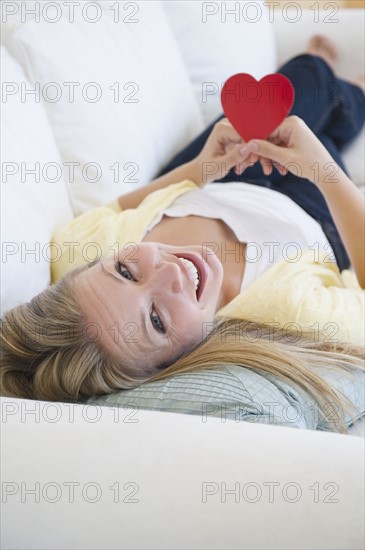 USA, New Jersey, Jersey City, Attractive young woman holding red heart. Photo : Jamie Grill Photography