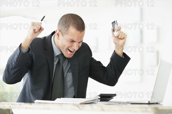 South Africa, Young happy businessman in office. Photo : momentimages