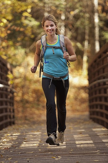 USA, Utah, young woman jogging on footbridge. Photo : Mike Kemp