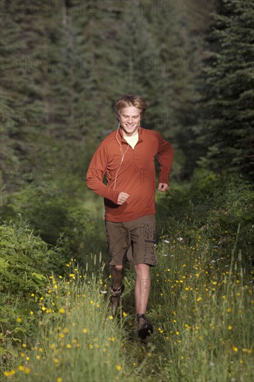 Canada, British Columbia, Fernie, young man jogging in forest. Photo : Dan Bannister