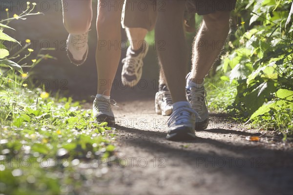 Canada, British Columbia, Fernie, Foot of three jogging people. Photo : Dan Bannister