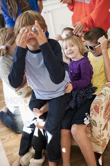 USA, Utah, Portrait of kids (2-3, 6-7, 8-9, 10-11, 10-11) playing in living room. Photo : Tim Pannell