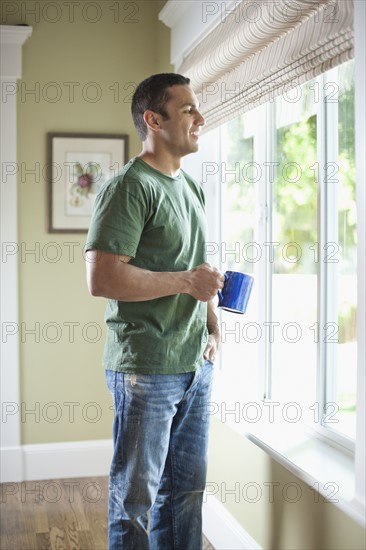 USA, Utah, Young man looking through window. Photo : Tim Pannell
