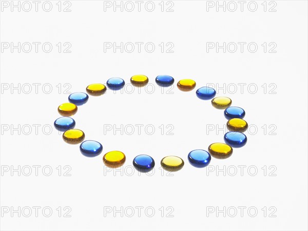 Studio shot of blue and yellow glass beads in circle. Photo : David Arky