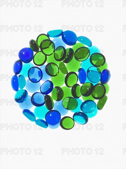 Studio shot of blue and green glass beads in sphere. Photo : David Arky