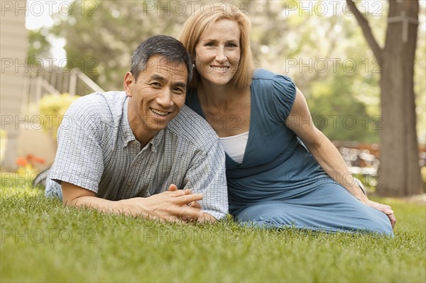 USA, Utah, Provo, Portrait of smiling mature couple sitting on lawn in garden. Photo : FBP