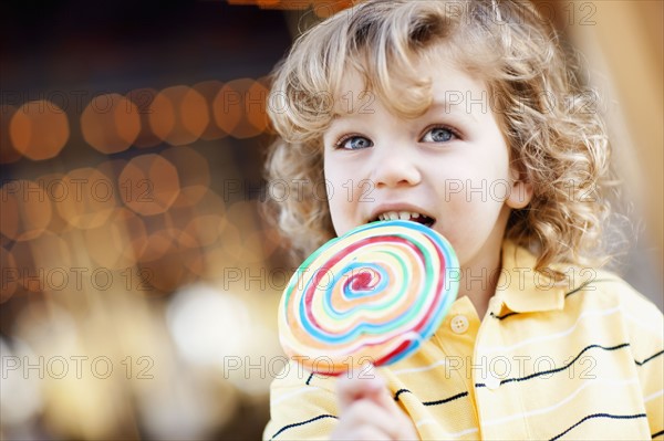 USA, California, Los Angeles, Boy (4-5) holding lollipop and looking away. Photo : FBP