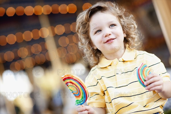 USA, California, Los Angeles, Boy (4-5) holding lollipop and looking away. Photo : FBP