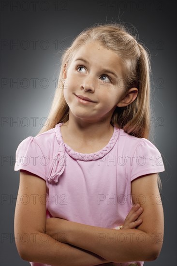 Portrait of girl (8-9) looking up, studio shot. Photo : FBP