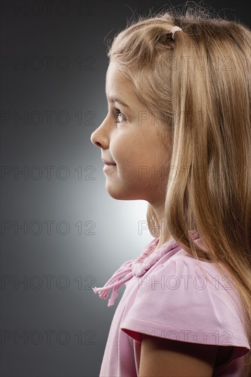 Girl (8-9) looking up, studio shot. Photo : FBP