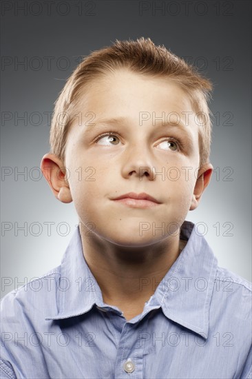 Portrait of boy (8-9) wearing shirt and looking away, studio shot. Photo : FBP