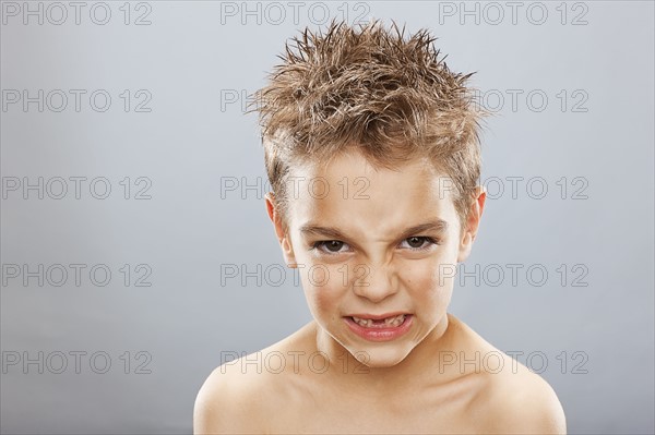 Studio portrait of angry toothless boy (8-9) . Photo : FBP