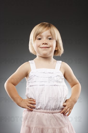 Girl (2-3) with hands on hip and looking at camera, studio shot. Photo : FBP