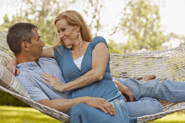 USA, Utah, Provo, Smiling mature couple relaxing in hammock in garden. Photo : FBP