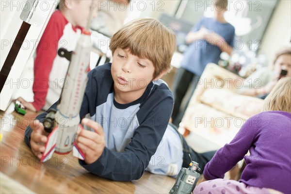 USA, Utah, Boy (8-9) playing on floor. Photo : Tim Pannell