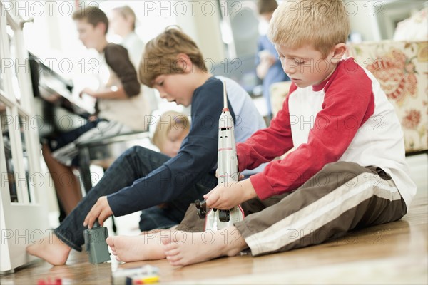 USA, Utah, Boys (6-7, 8-9) playing on floor. Photo : Tim Pannell