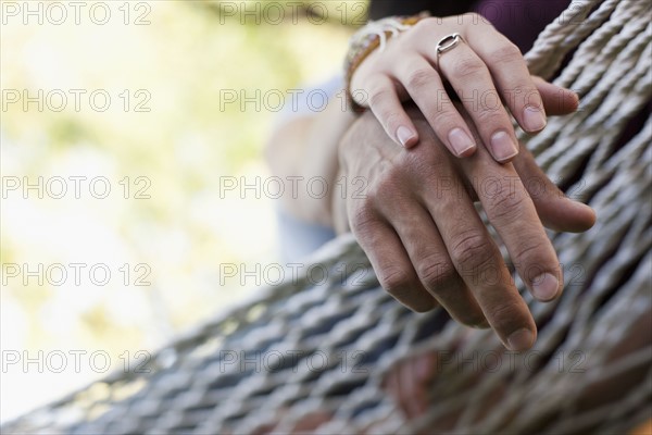 USA, Utah, close up of couple's hands on hammock. Photo : Tim Pannell