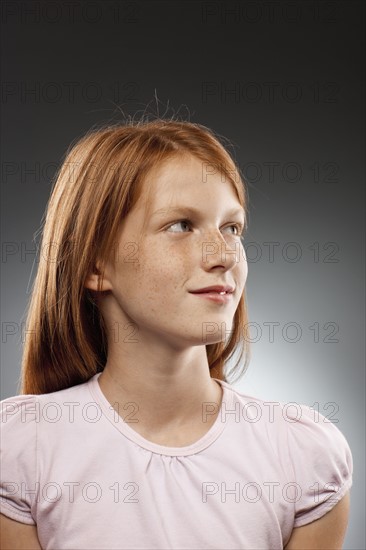 Portrait of redhead girl (10-11) looking away, studio shot. Photo : FBP