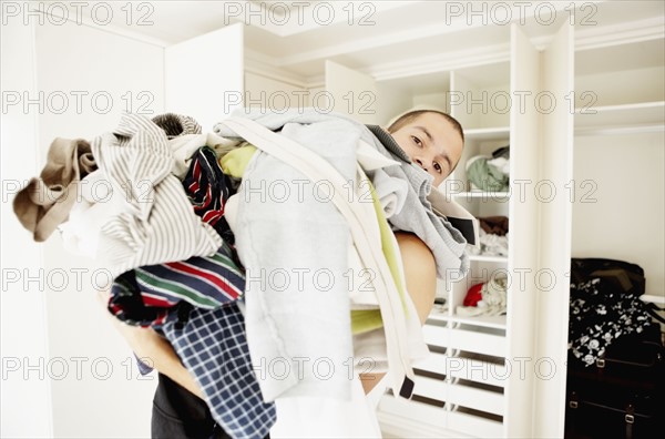 South Africa, Man standing with pile of laundry. Photo : momentimages