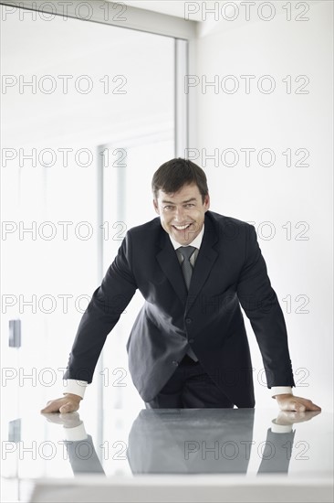 South Africa, Mid adult businessman in office smiling. Photo : momentimages