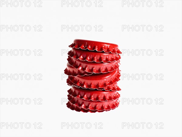 Studio shot of heap of red bottle caps. Photo : David Arky