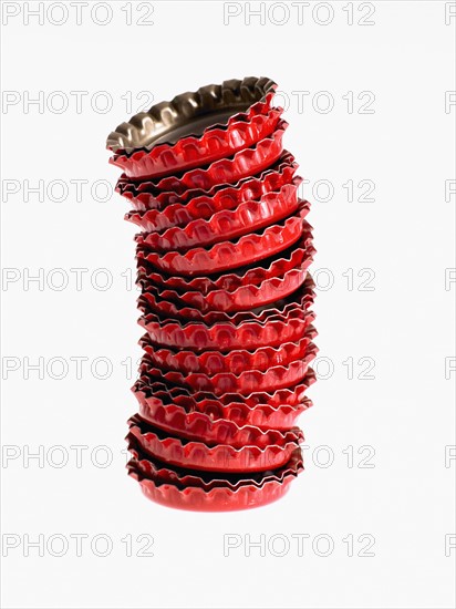 Studio shot of heap of red bottle caps. Photo : David Arky