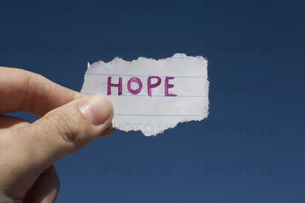 USA, Arizona, Winslow, Human hand holding paper with "hope" text on it. Photo : David Engelhardt