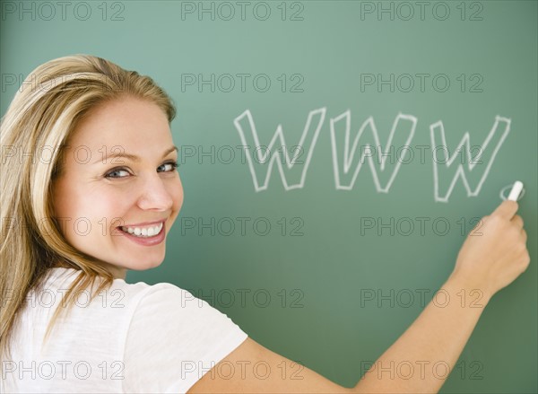 USA, New Jersey, Jersey City, Young attractive woman writing www on blackboard. Photo : Jamie Grill Photography