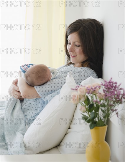 USA, New Jersey, Jersey City, Mother laying in bed with baby daughter (2-5 months). Photo : Jamie Grill Photography