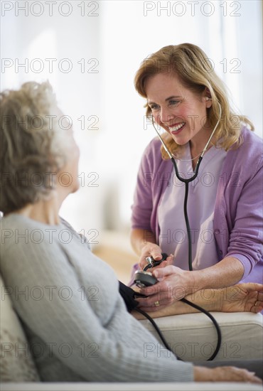 USA, New Jersey, Jersey City, Female nurse checking patients blood pressure.