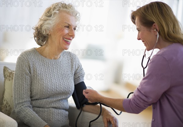 USA, New Jersey, Jersey City, Female nurse checking patients blood pressure.