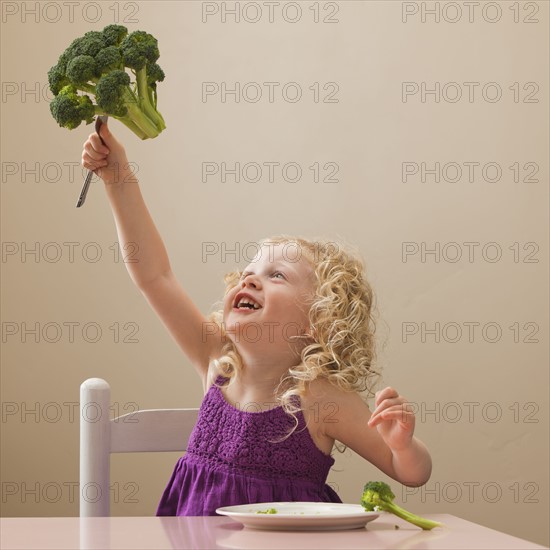 USA, Utah, Lehi, girl (2-3) holding broccoli. Photo : Mike Kemp