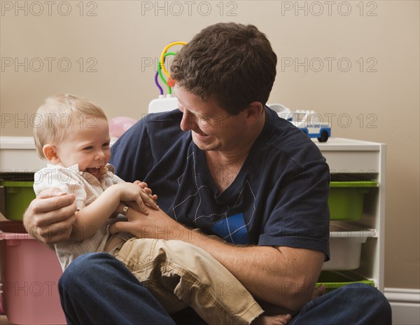 USA, Utah, father tickling son (18-23 months). Photo : Mike Kemp