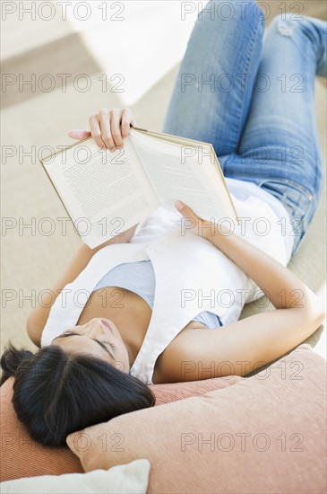 USA, New Jersey, Jersey City, Elevated view of young woman reading book. Photo : Daniel Grill